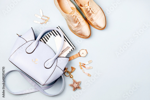 Cute blue ladies bag, stylish golden shoes and  feminine accessories . Flat lay, top view. Spring fashion concept in pastel colored photo