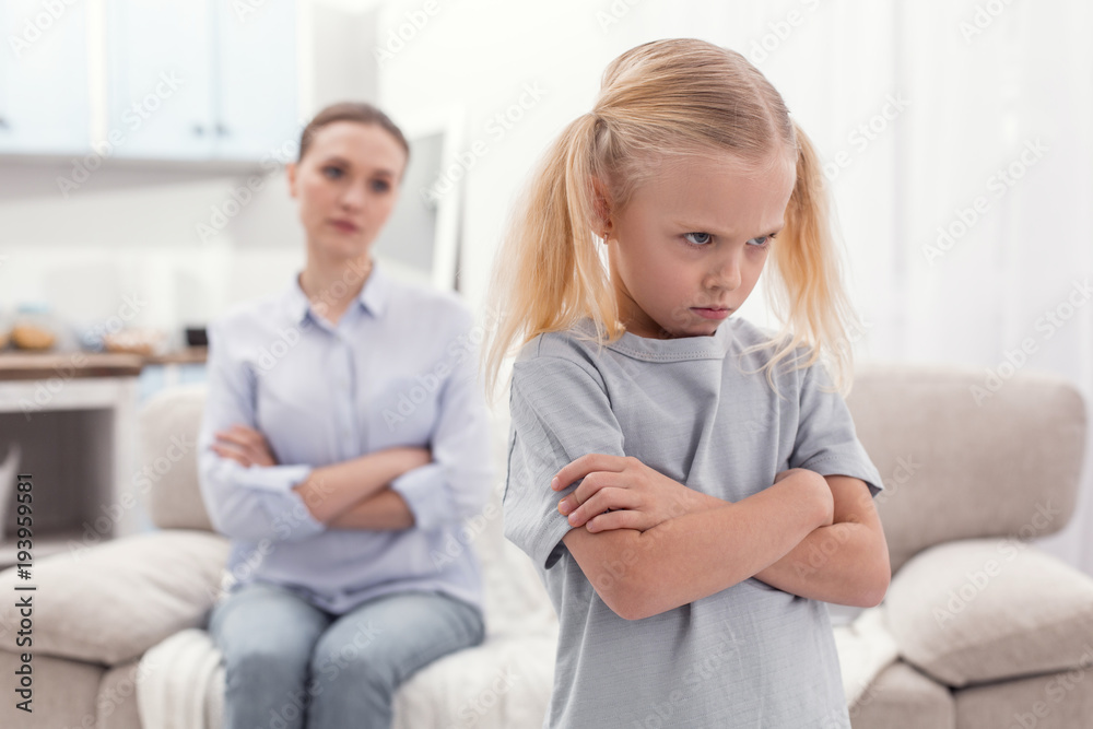 Huge offense. Unsatisfied angry displeased girl crossing arms while frowning and turning with back to mom