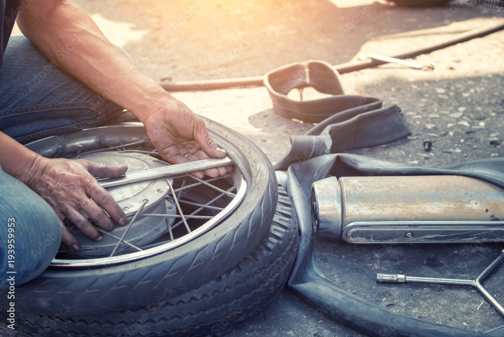 Motorcycle repair after a tire leak during a long journey. Modifying some parts of a motorcycle when it is used for a certain period of time by an expert technician.