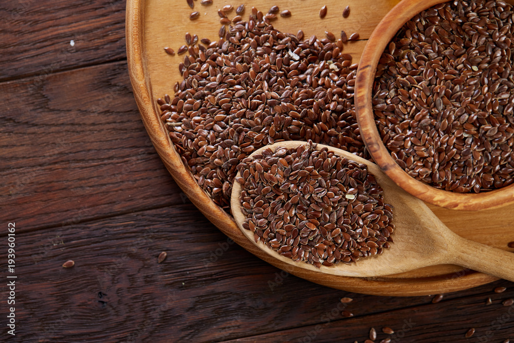 Flax seeds in wooden bowl and spoon on rustic wooden background, top view,  shallow depth of field Stock Photo | Adobe Stock