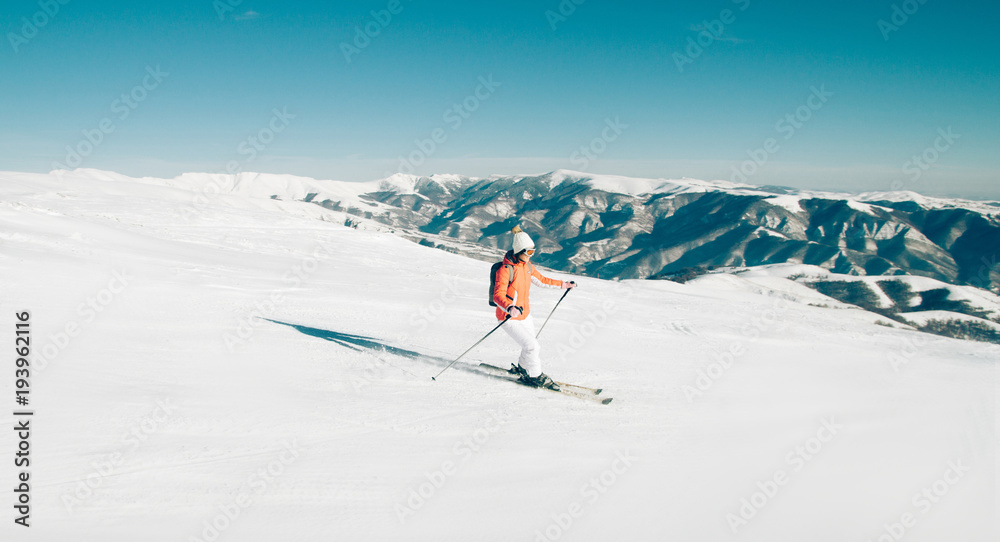 Woman Skier skiing down the slope in winter mountains