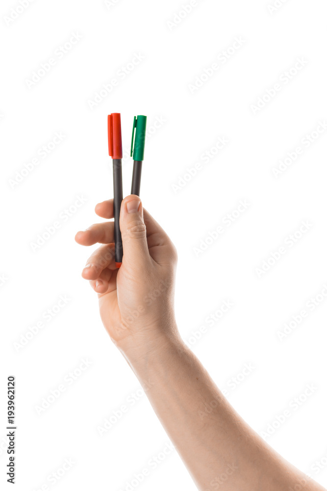 Male hand holds a two red and green markers or a felt pen. Isolated on white background. Male hand holds a two red and green markers or a felt pen. Isolated on white background.