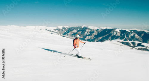 Woman Skier skiing down the slope in winter mountains