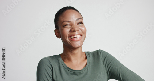 black woman with a short haircut in studio shootsmiling and wearing dress photo