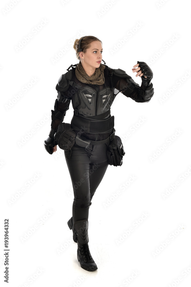 full length portrait of female soldier wearing black tactical armour, isolated on white studio background. full length portrait of female soldier wearing black tactical armour, isolated on white studio background.