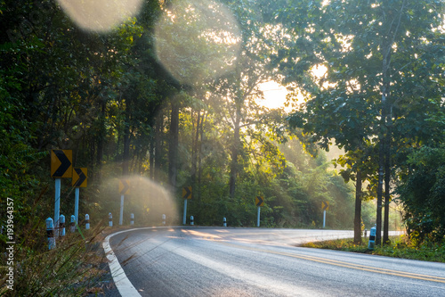 Small and curve upcountry or outback road when sunshine in the morning time , flare light photo