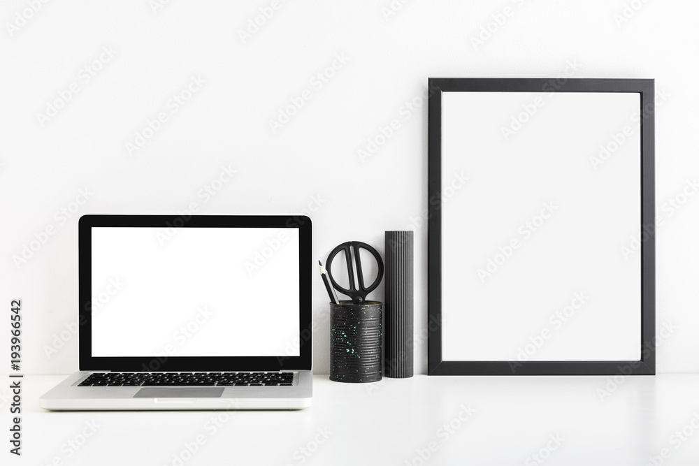 Macbook laptop, photo frame,office supplies and a cactus on a desk. Minimal white workspace Macbook laptop, photo frame,office supplies and a cactus on a desk. Minimal white workspace