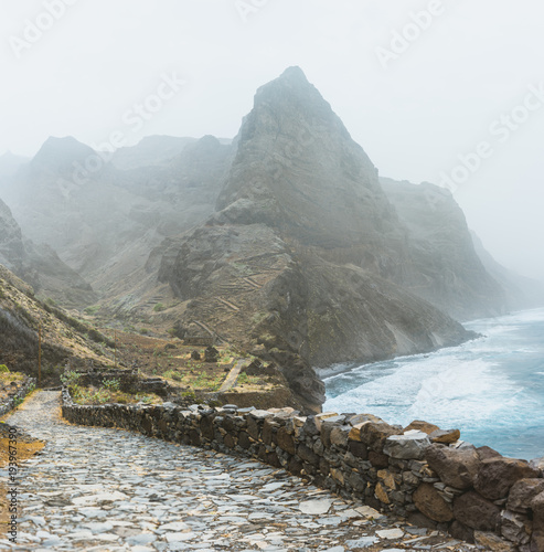 Stunning scenery of the coastal road. Steep black cliffs stretched out ahead, huge waves crashing against steep rocky shore. The road from Cruzinha to Ponta do Sol. Santo Antao. Cape Verde photo