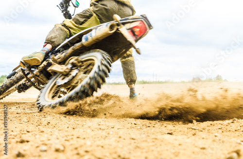 Close-up of mountain motocross race in dirt track in day time.
