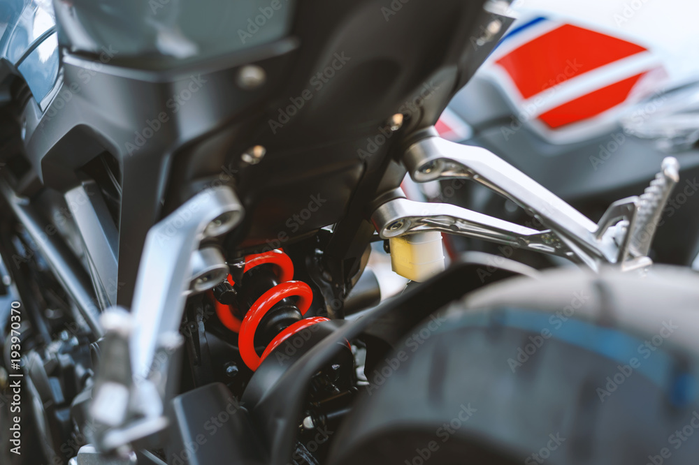 Naklejka premium closeup Shock absorber in the back of the motorcycle with soft-focus and over light in the background