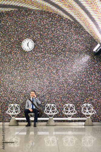 Photography Mature businessman with smartphone in a metro station.