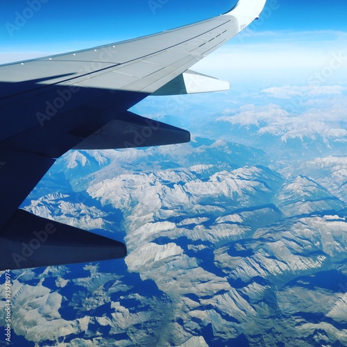 View from airplane flying over Alps mountains