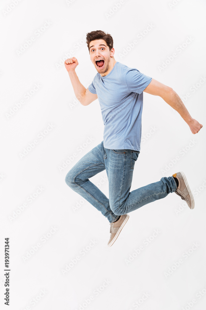Full-length photo of funny man 30s in casual t-shirt and jeans running or  jumping in air, isolated over white background Stock Photo | Adobe Stock