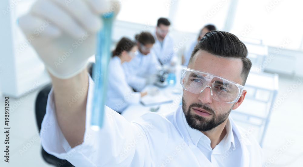 image is blurred. young scientist holding tube with the reagents image is blurred. young scientist holding tube with the reagents
