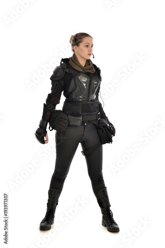 full length portrait of female  soldier wearing black  tactical armour, isolated on white studio background. © faestock