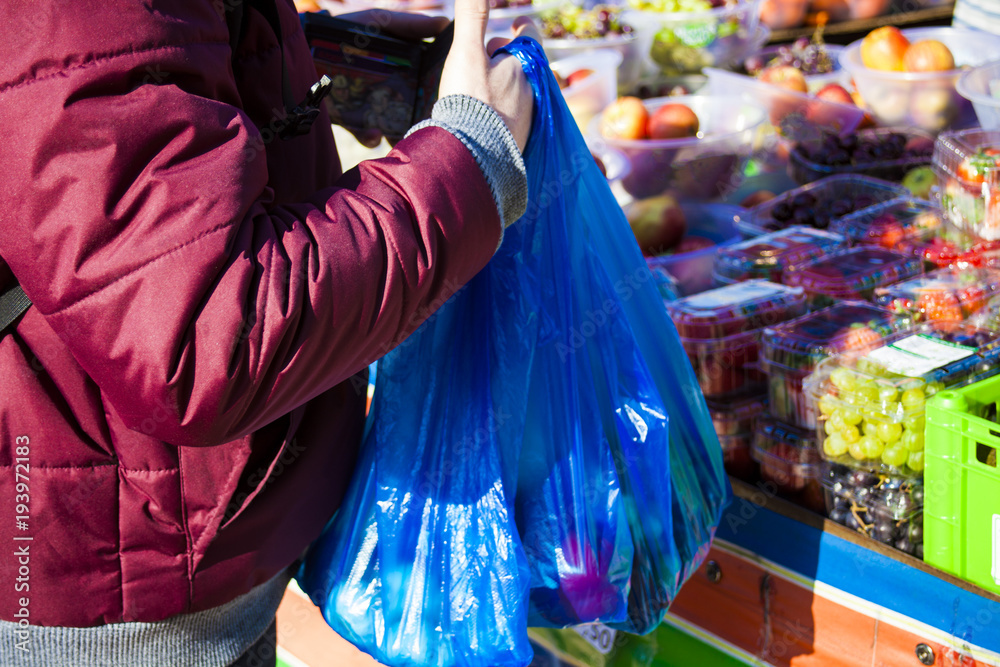 Male consumer at an open street market shopping fruit and vegetables. Street market. Helthy food. Male consumer at an open street market shopping fruit and vegetables. Street market. Helthy food.