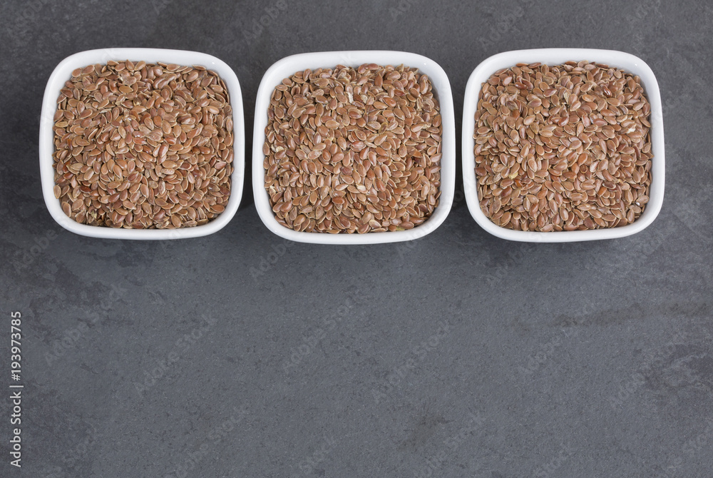 Organic flax seeds in the bowls - Linum usitatissimum Organic flax seeds in the bowls - Linum usitatissimum