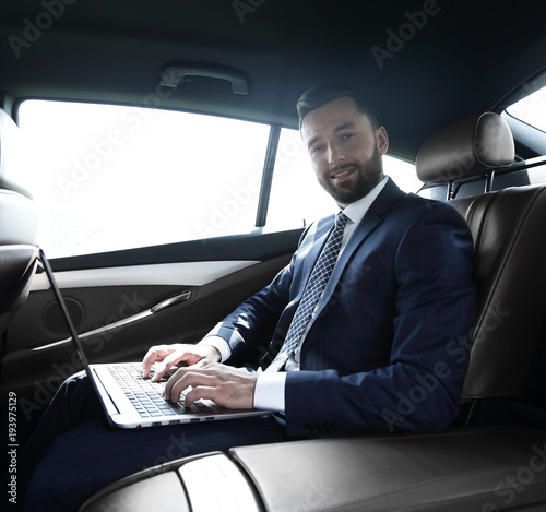 young businesswoman working on her laptop while sitting in the car © ASDF