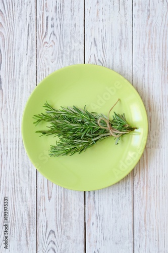 Bunch of rosemary on green plate