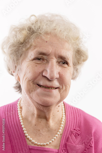 An elderly woman with gray curly hair laughs