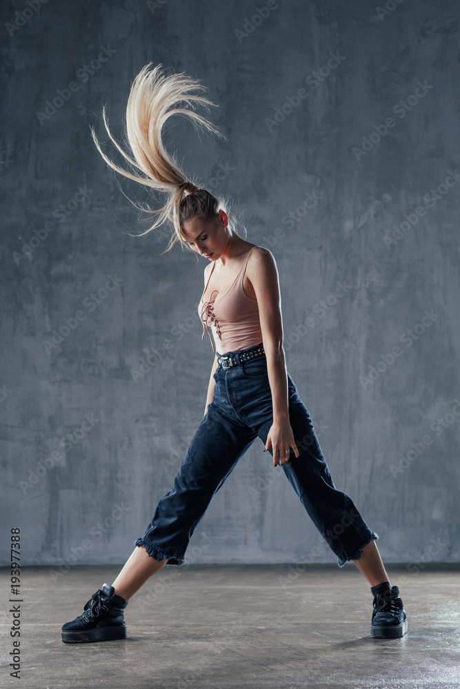 Fototapeta premium Young beautiful female dancer is posing in the studio