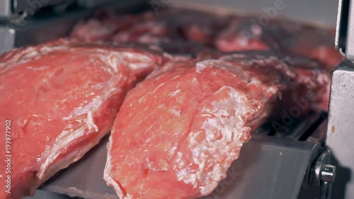 Close up of meat slabs being extruded by a factory machine photo