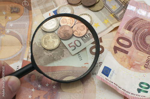 Monedas y billetes de euro con lupa