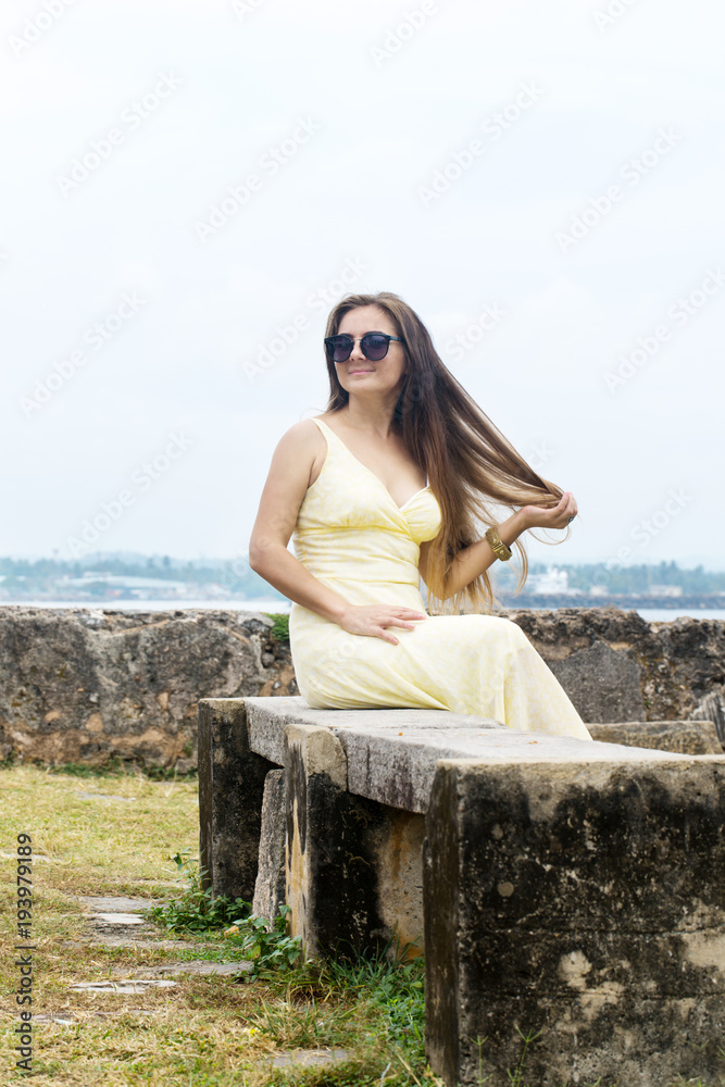 A woman sits on a stone