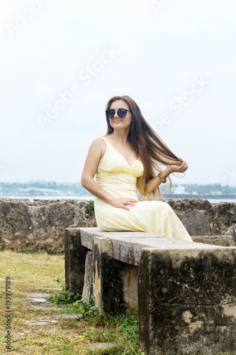 A woman sits on a stone