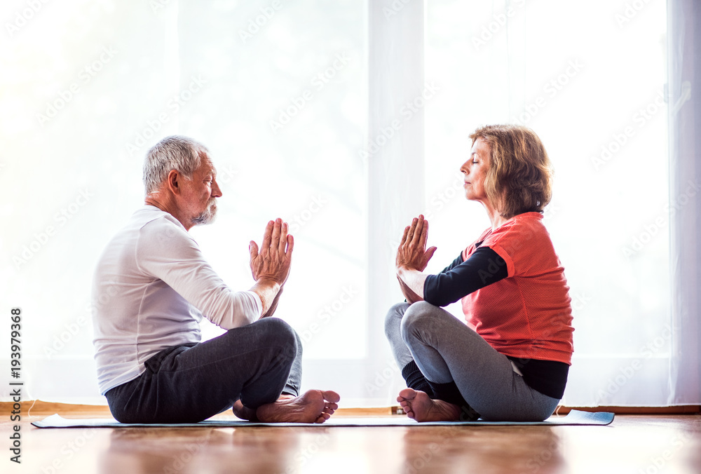 Fotografie Senior couple meditating at home.