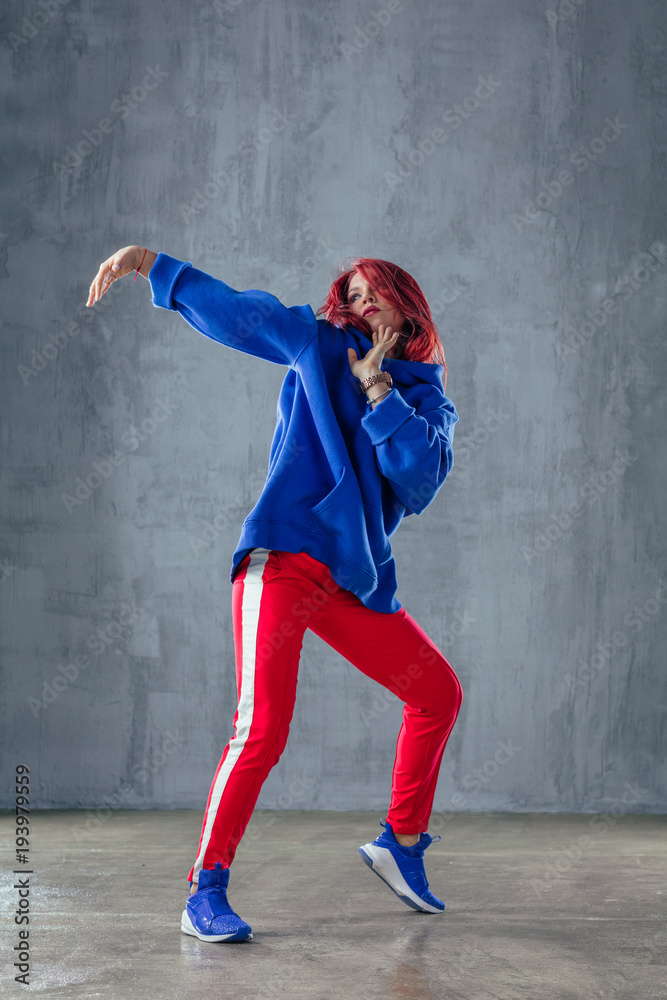 Young beautiful female dancer is posing in the studio