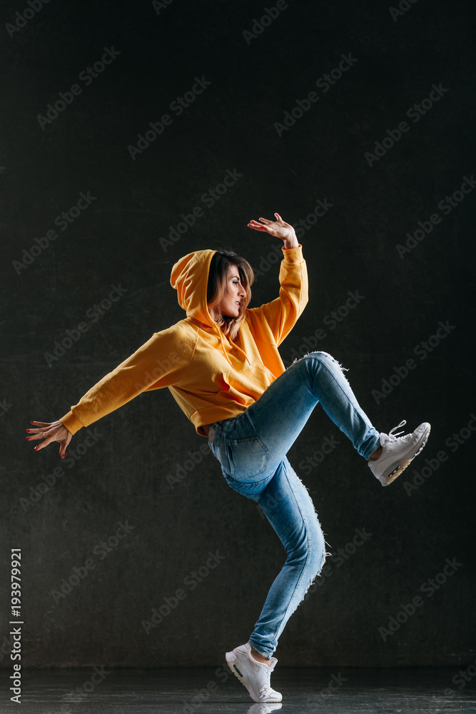 Young beautiful female dancer is posing in the studio