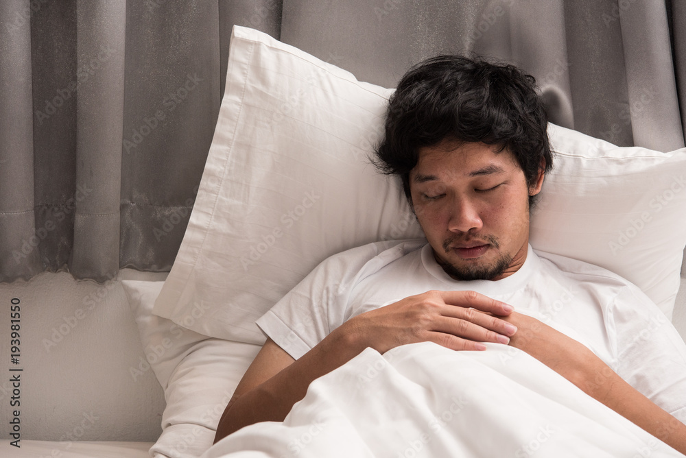Laziness of Asian man that still sleeping on the bed in bedroom in morning, time to wake up. Laziness of Asian man that still sleeping on the bed in bedroom in morning, time to wake up.