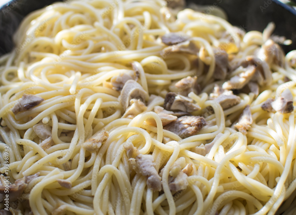 Preparation of spaghetti with chopped meat in a frying pan.