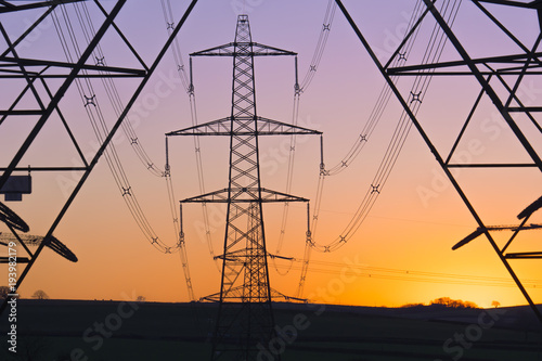 An electricity pylon of the National Grid in Wales at sunset.