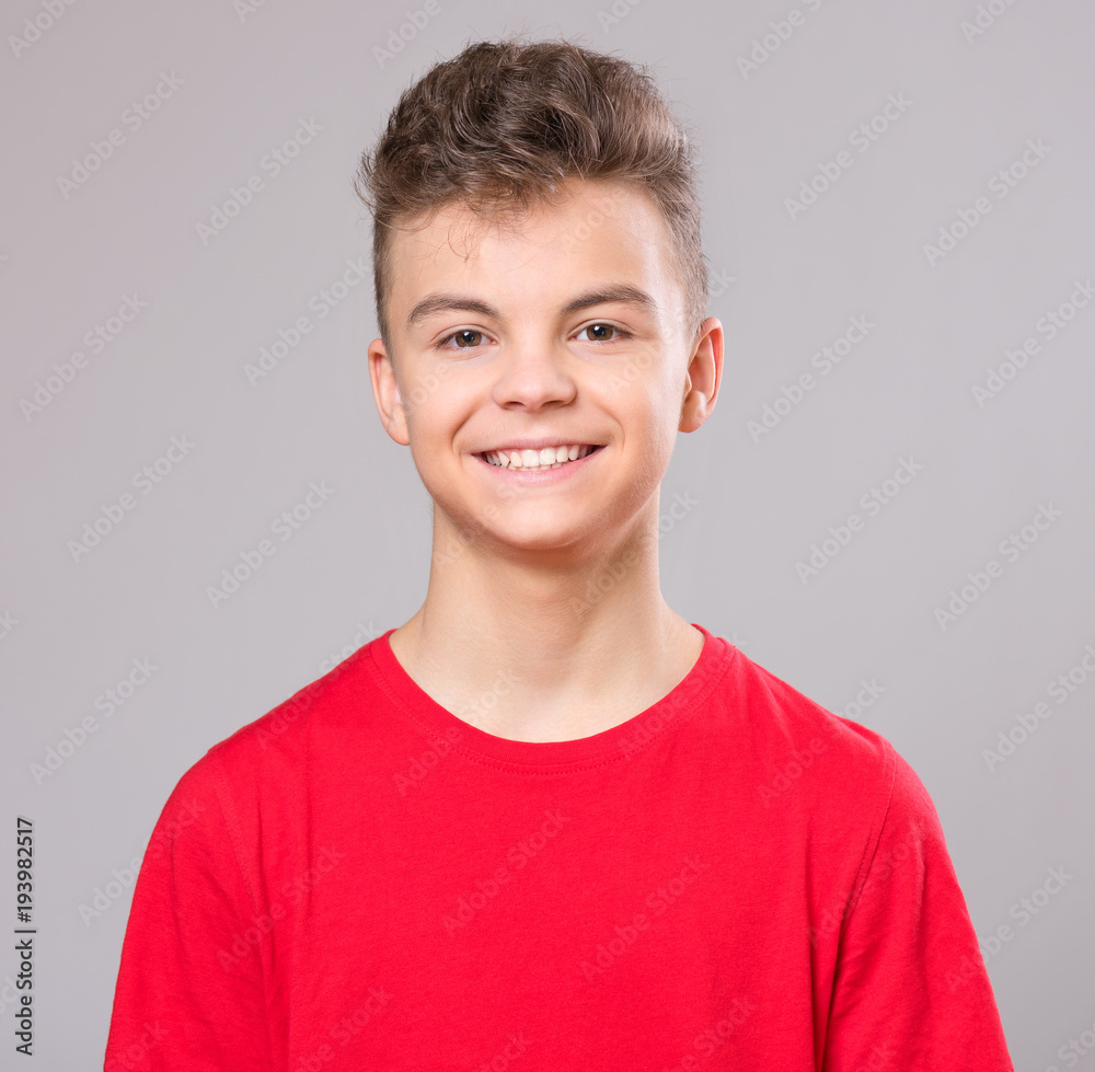 Close up emotional portrait of caucasian teen boy. Handsome smiling guy. Funny cut teenager on gray background. Child looking at camera. Close up emotional portrait of caucasian teen boy. Handsome smiling guy. Funny cut teenager on gray background. Child looking at camera.
