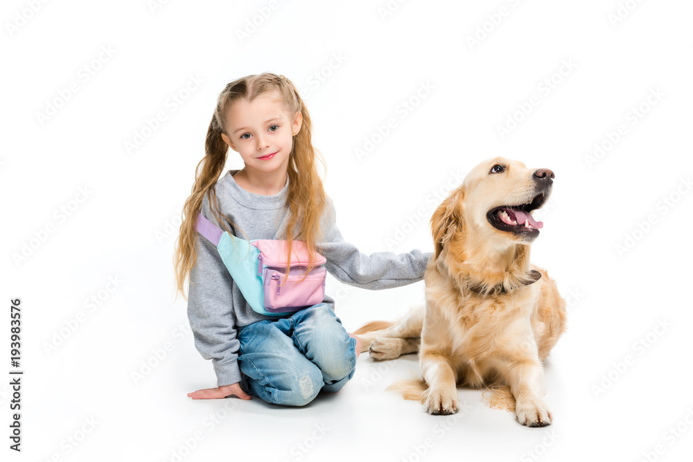 Portrait of little happy kid with dog lying beside isolated on white