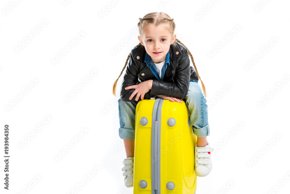 View of kid with pigtails sitting on yellow wheel suitcase isolated on white View of kid with pigtails sitting on yellow wheel suitcase isolated on white