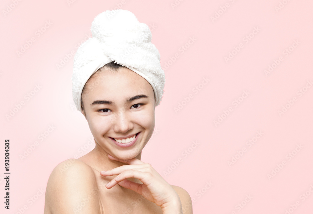 Indoor portrait of cheerful smiling attractive asian woman holding white towel on head wrapped in yellow towel isolated on the rose background. Beauty, skincare, lifestyle concept Indoor portrait of cheerful smiling attractive asian woman holding white towel on head wrapped in yellow towel isolated on the rose background. Beauty, skincare, lifestyle concept