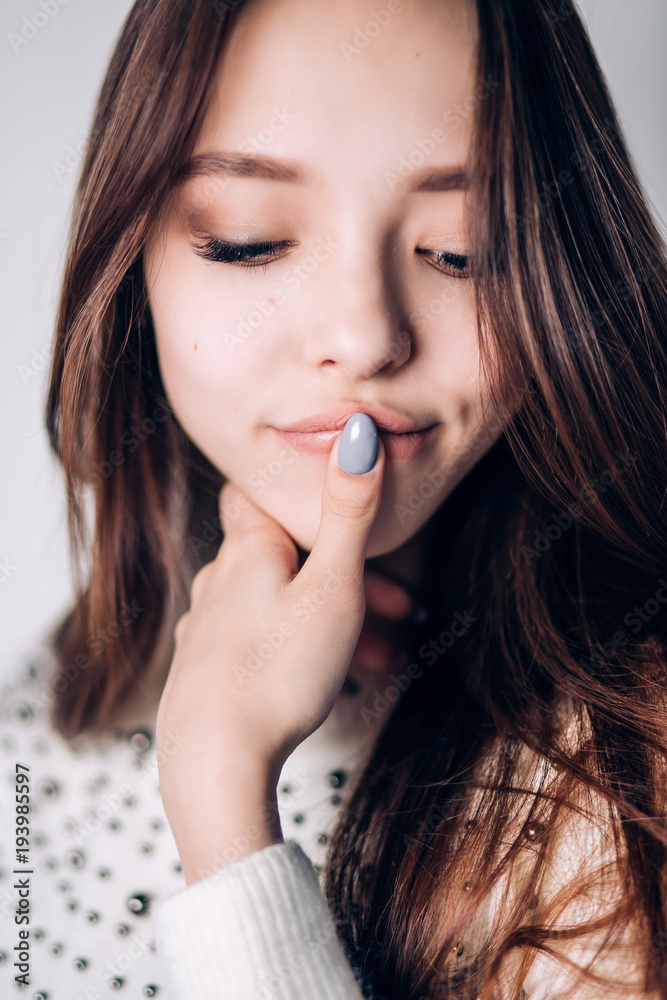 portrait of smiling woman. finger on lips, look down. portrait of smiling woman. finger on lips, look down.