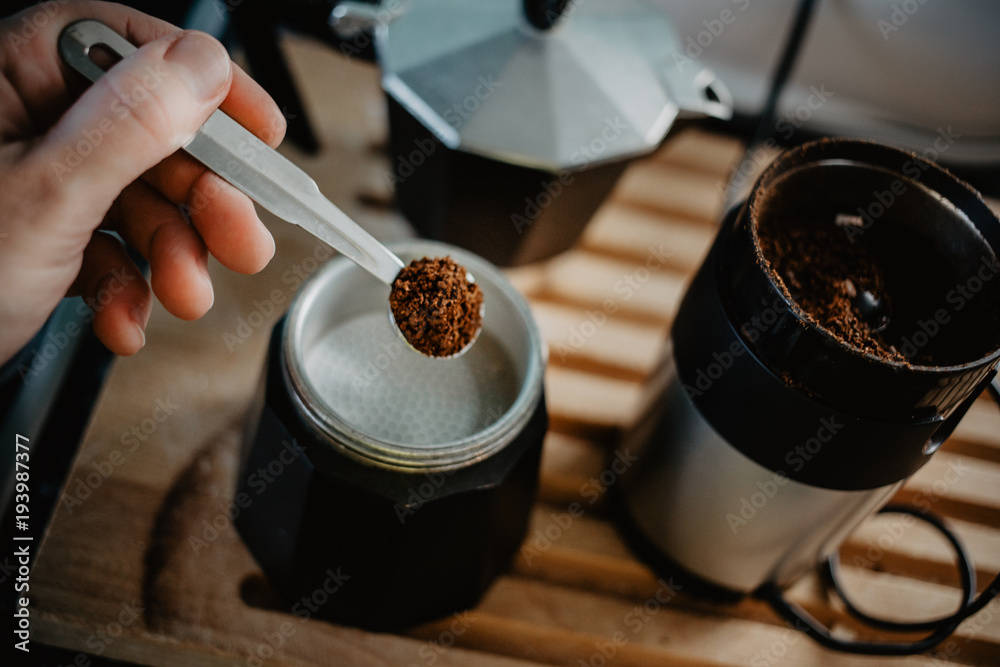 Preparing fresh coffee in moka pot on electric stove. Measuring ground