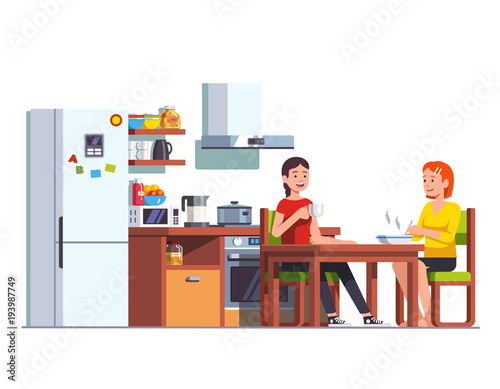 Two girls eating lunch together at home kitchen