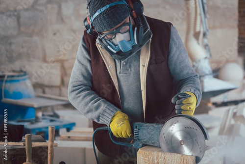 Stonemason cutting stone with saw in workshop photo