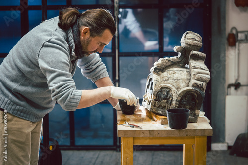 Stonework conservator working on preservation of historical piece 