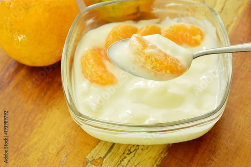 yogurt topping orange scooping on spoon in glass cup