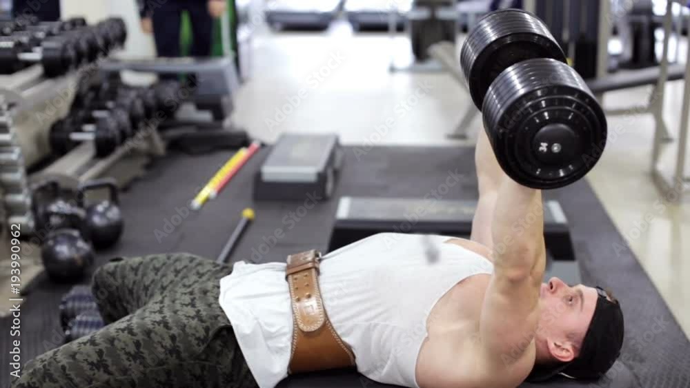 Bodybuilder doing exercises with dumbbells Bodybuilder doing exercises with dumbbells