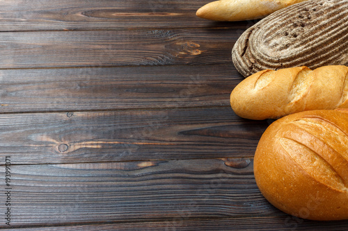 freshly baked bread on wooden background, top view