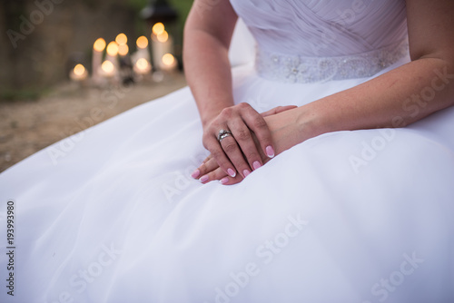 Morning of bride, with her hands crossed.  An engagement ring with a diamond on the finger of the right hand. Female fingernails with french manicure. Getting ready for wedding ceremony. 