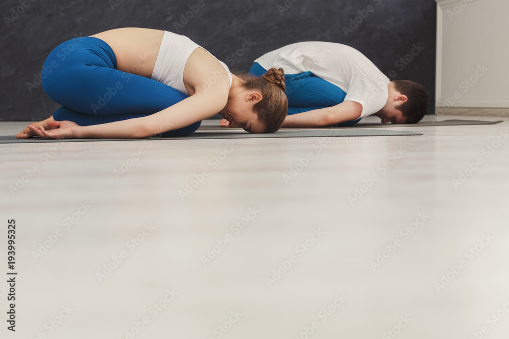 Young couple meditating together in gym Young couple meditating together in gym