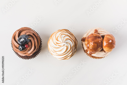 top view of arrangement of tasty cupcakes isolated on white